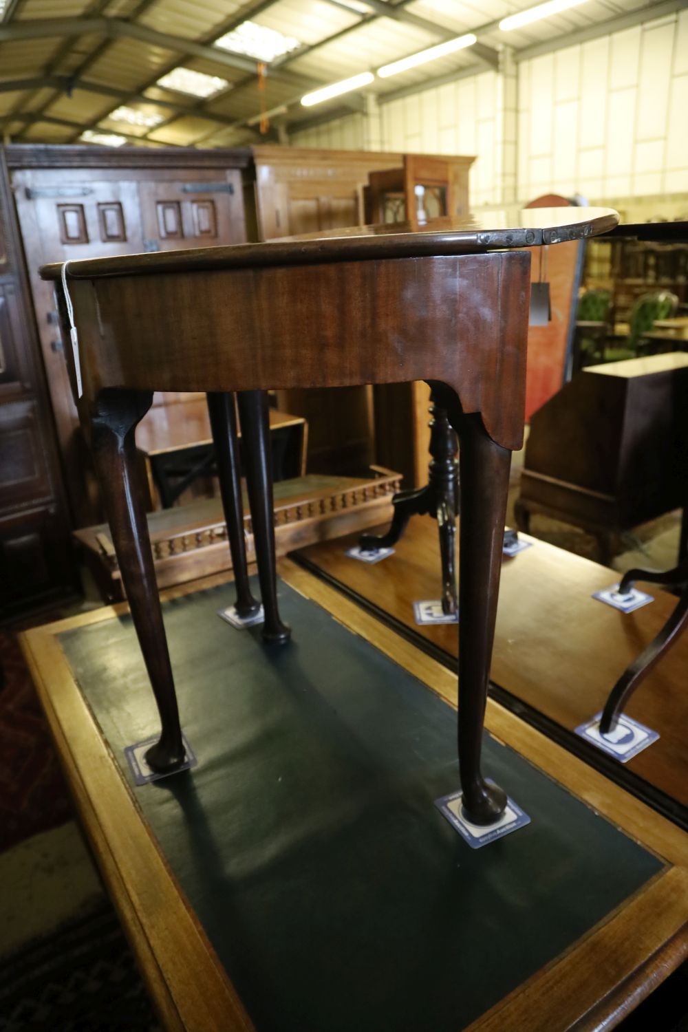 A George II mahogany and fruitwood games table, with hinged top and raised on pole and pad supports, width 75cm, depth 38cm, height 73c